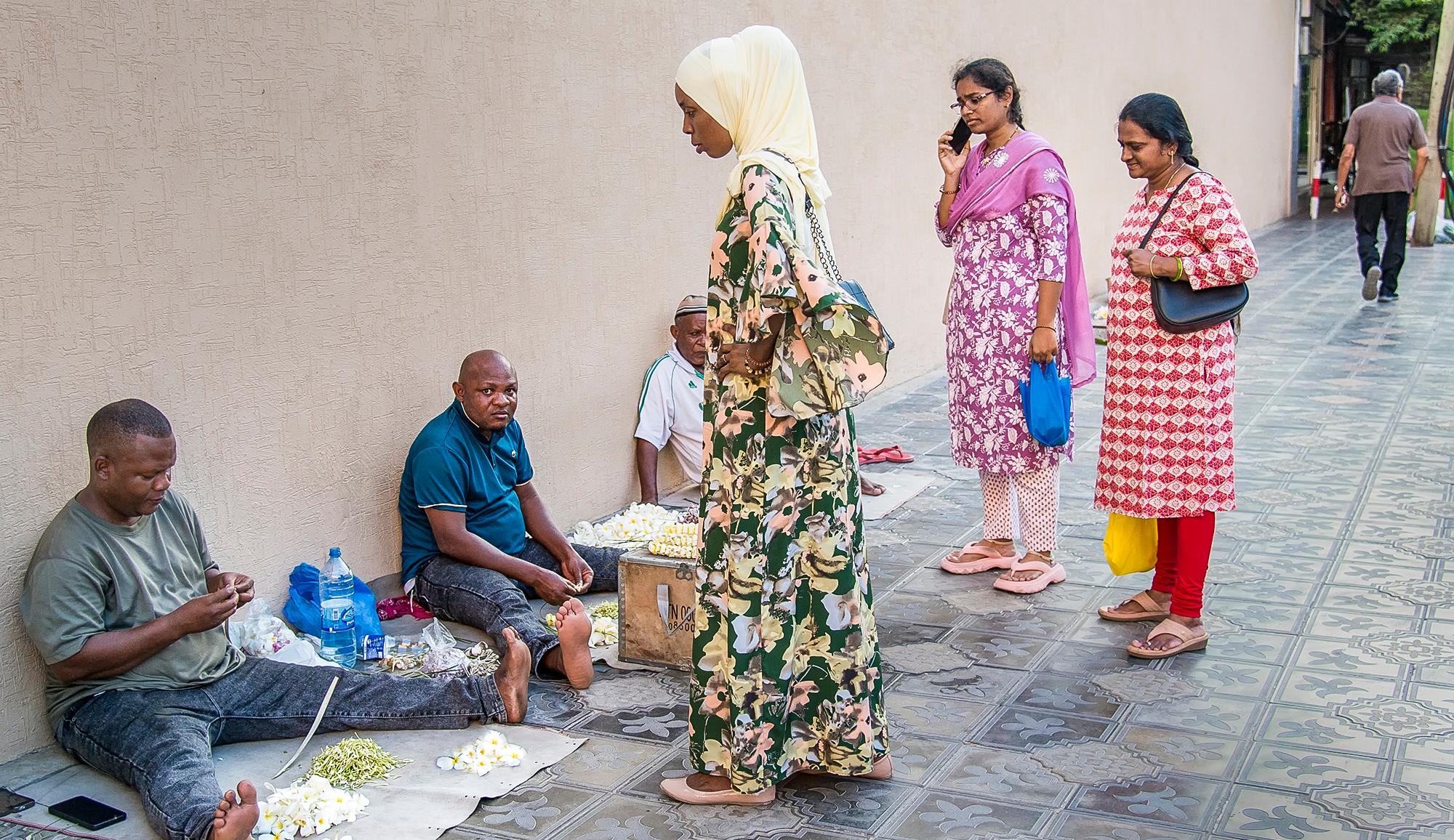 Harmonious integration: (above) Flower garland vendors at a temple in Dar es Salaam; (opposite) the T.B. Sheth Library houses 7,000 books in Gujarati; (below) a young local vendor proudly displays savory snacks in a Dar es Salaam Indian food shop